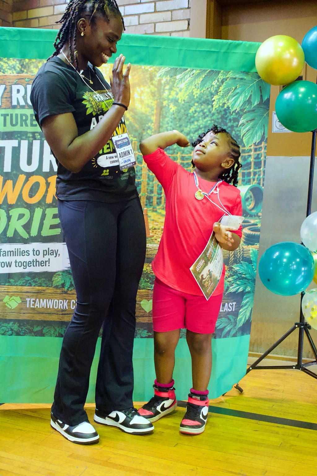 A Family Rush Adventures adult teammate and child sharing a high-five